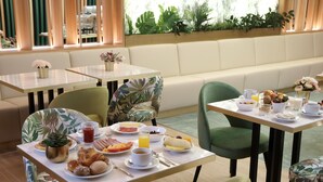 A breakfast setting with tables, chairs, and a variety of food items. - New Style Lisbon Hotel  (Lisbon)