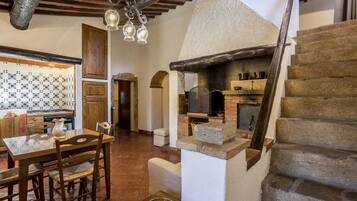 Un intérieur rustique comprenant un coin repas, une cuisine et un escalier.