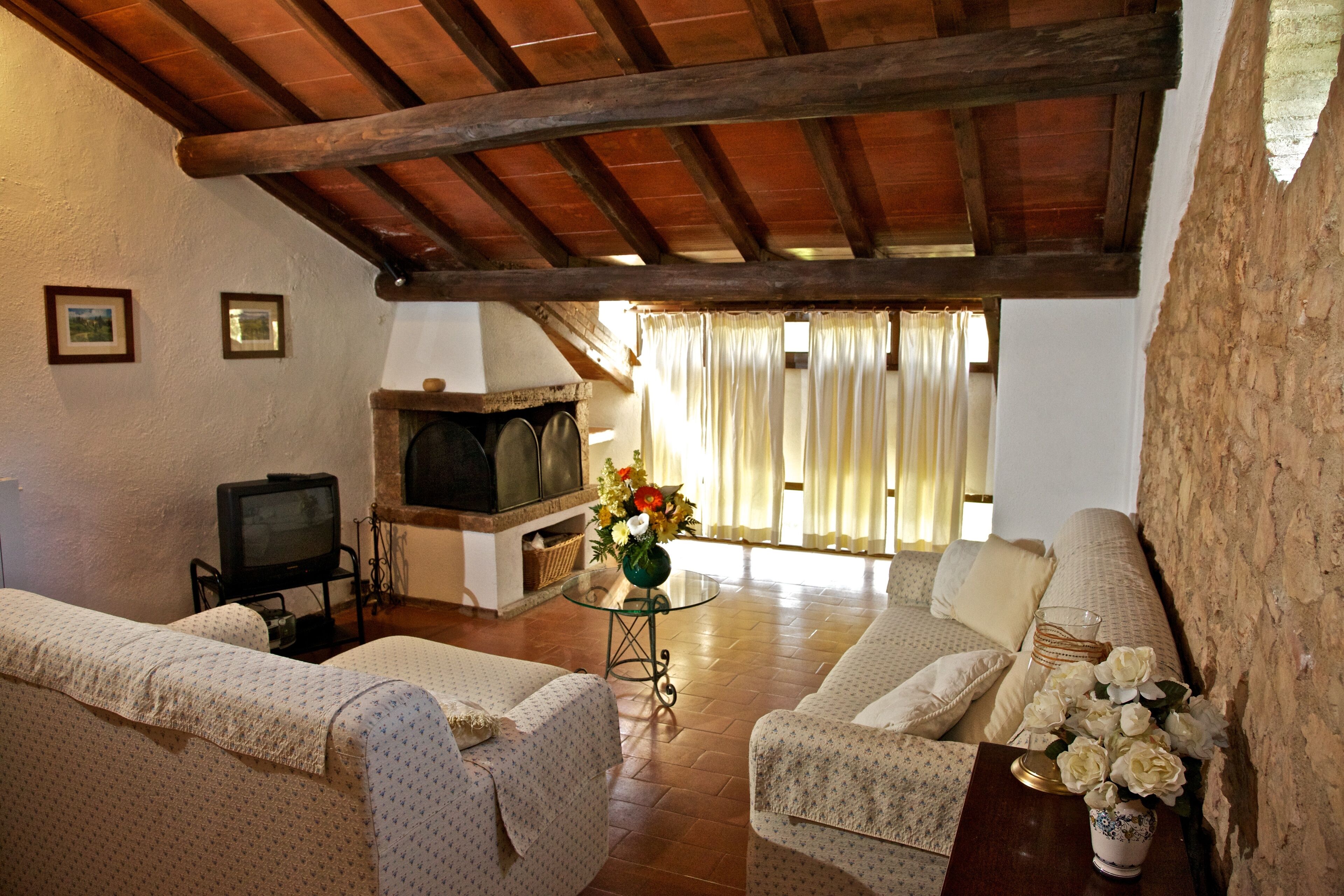 Ein gemütliches Wohnzimmer mit Kamin, Sofas und Fernseher.