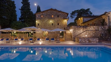 Una piscina al aire libre, sillones reclinables de piscina