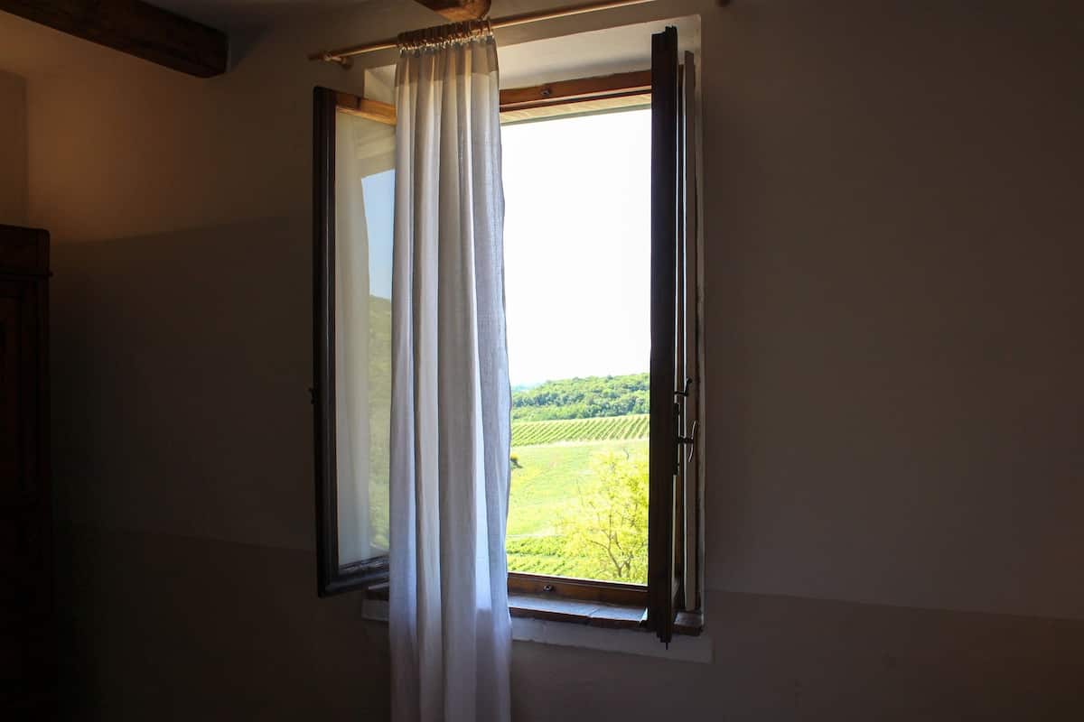 Une pièce avec une fenêtre donnant sur un paysage verdoyant.