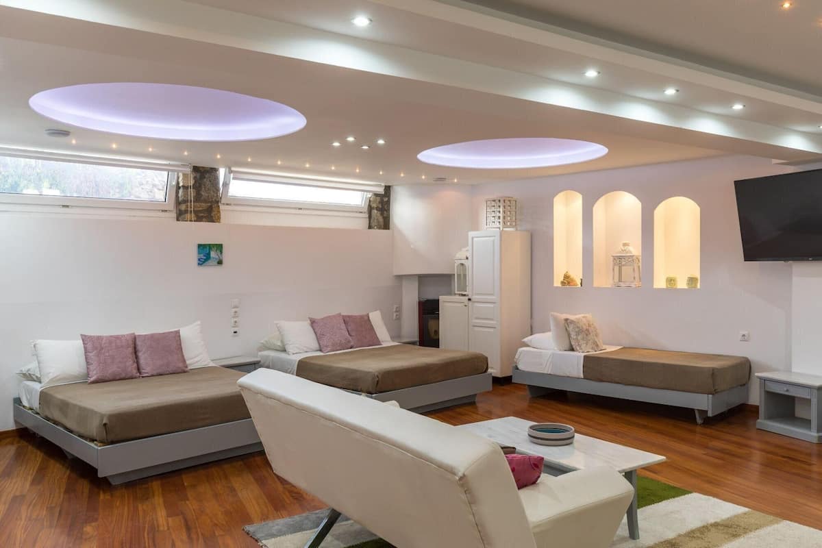 Una sala de estar moderna con dos sofás, una mesa de centro y un televisor de pantalla plana montado en la pared.