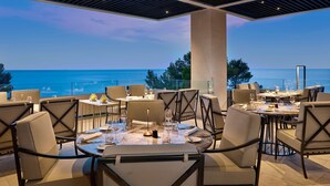An outdoor dining area with tables and chairs, overlooking a body of water. - Grand Hotel Brioni Pula A Radisson Collection Hotel (Pula)