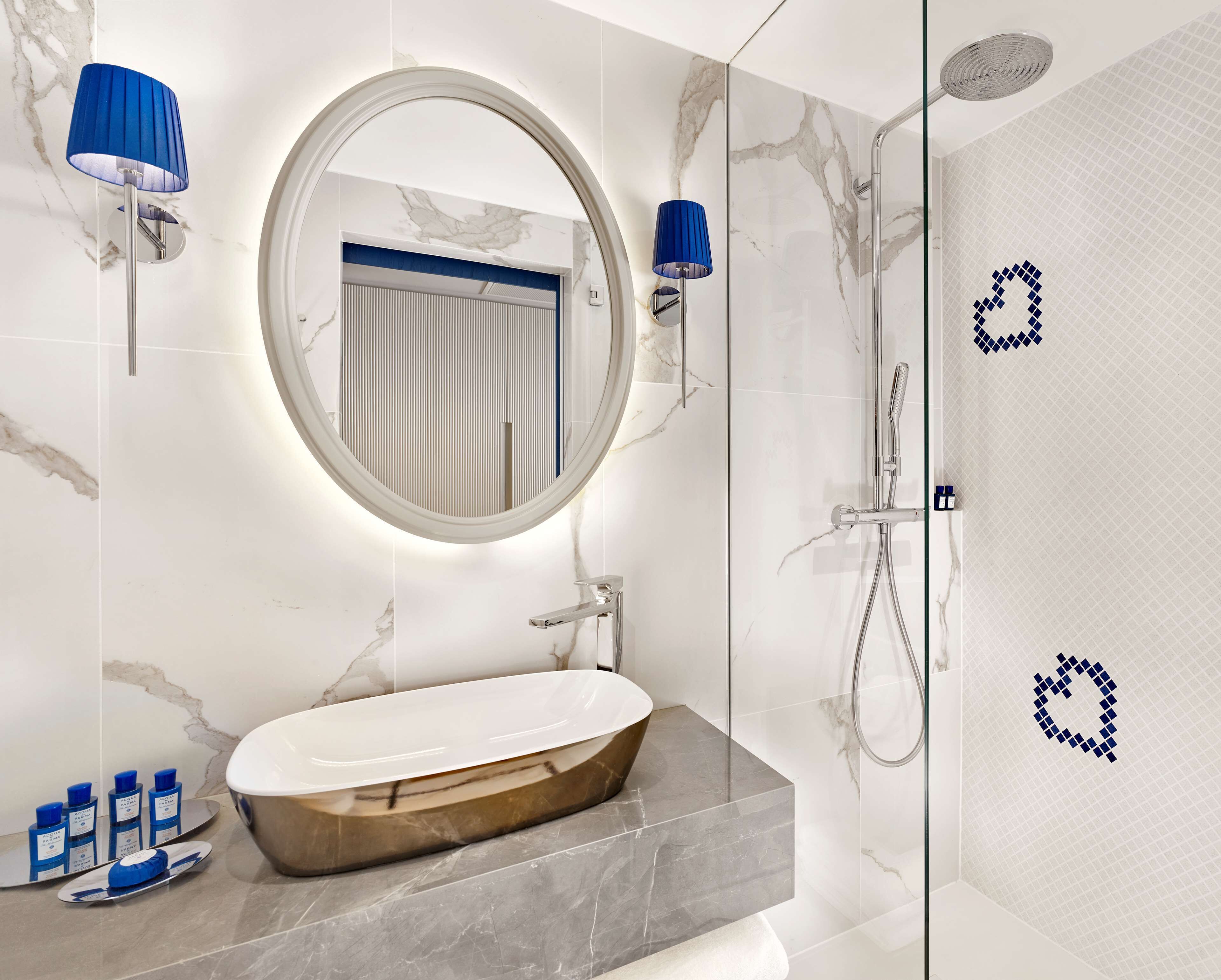 A modern bathroom with a freestanding bathtub, a round mirror, and a glass-enclosed shower area.