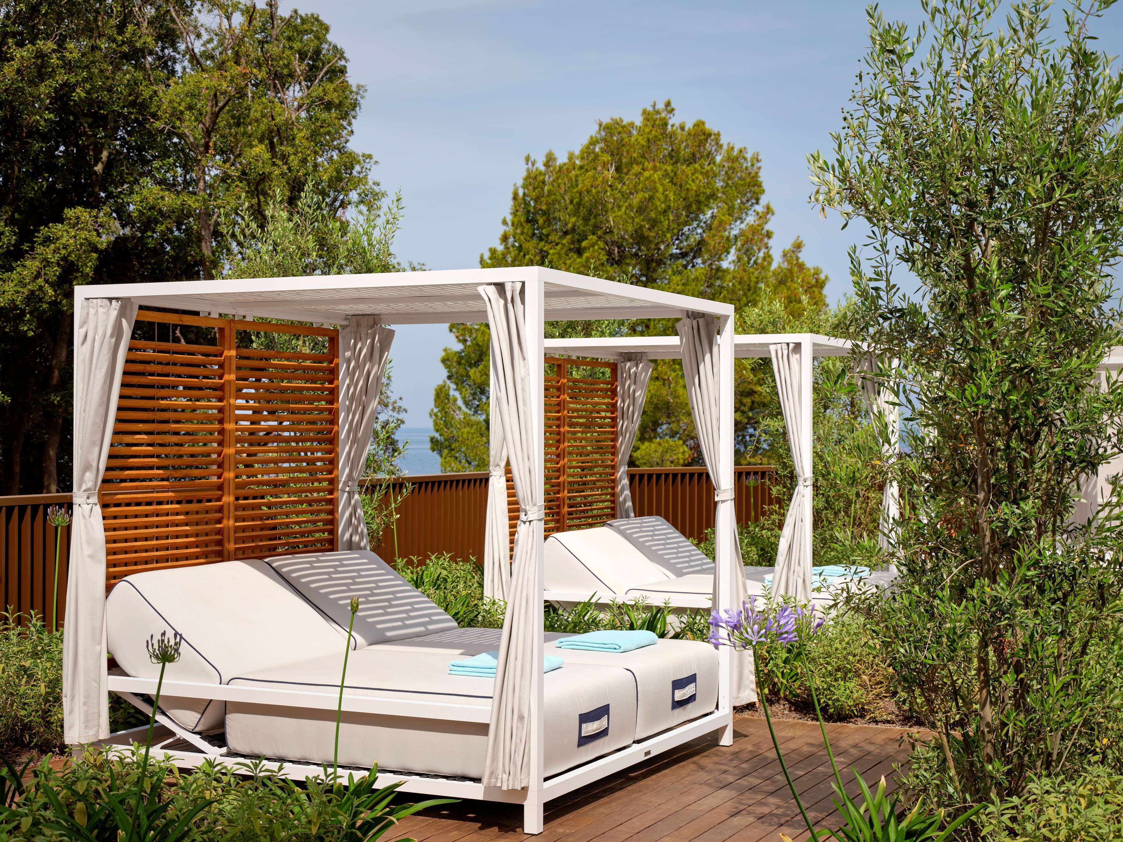Un espacio de estar al aire libre con techo, dos sillones reclinables y una toldo.