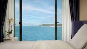 A bedroom with a large window offering a view of the sea and a distant island. - Grand Hotel Brioni Pula A Radisson Collection Hotel (Pula)