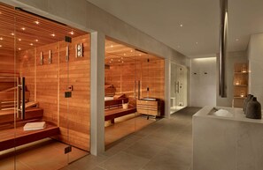 A modern spa with wooden paneling, a sauna, and a marble reception area.