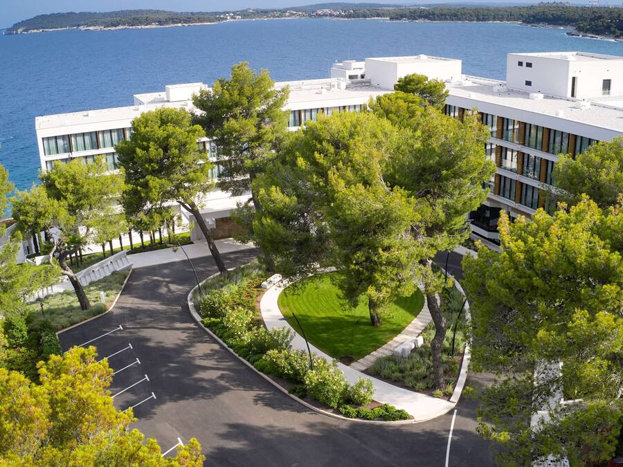A modern building with a parking lot and a view of the sea.