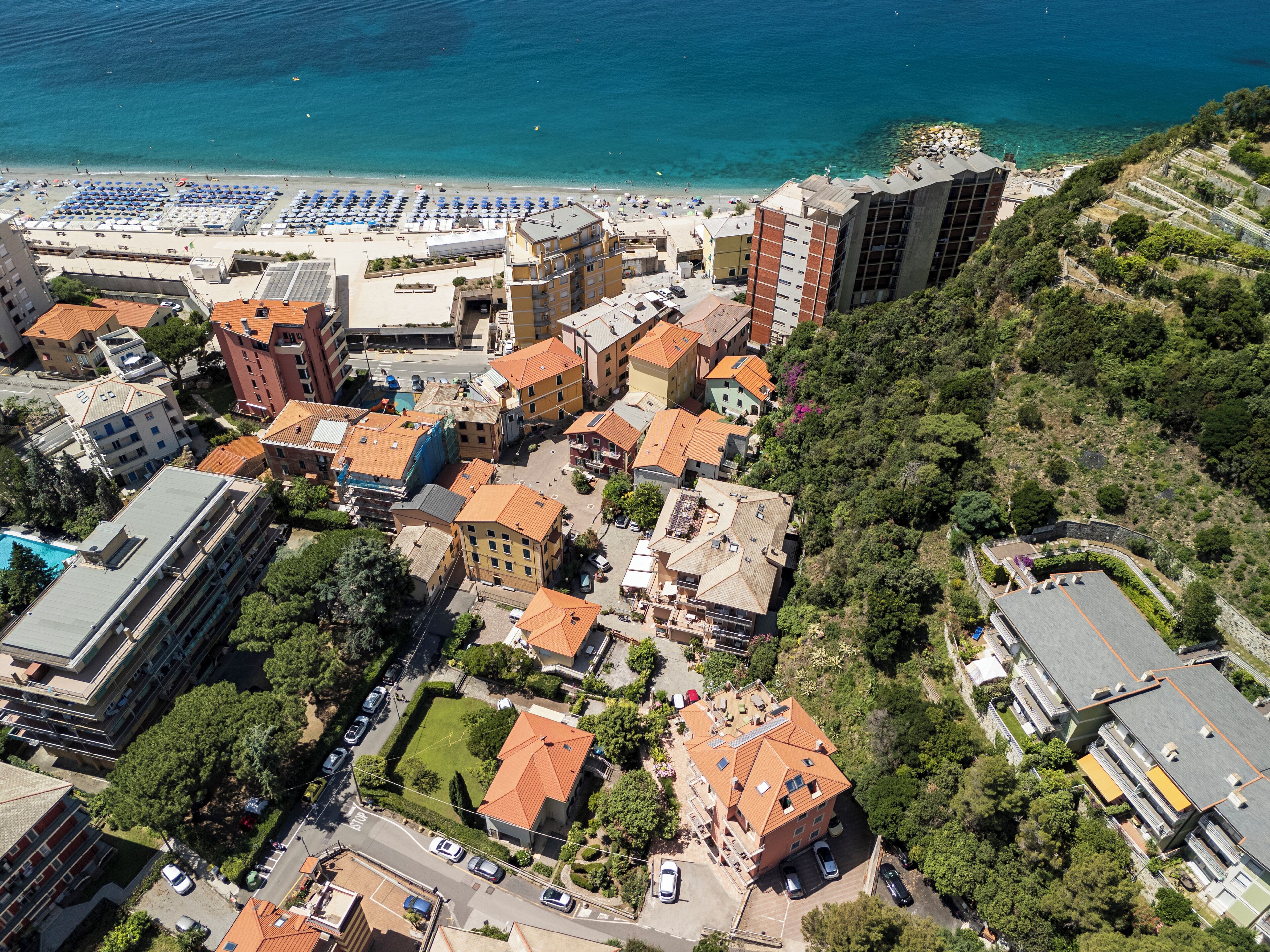 Vista aérea de un pueblo costero con edificios, una playa y un estacionamiento.