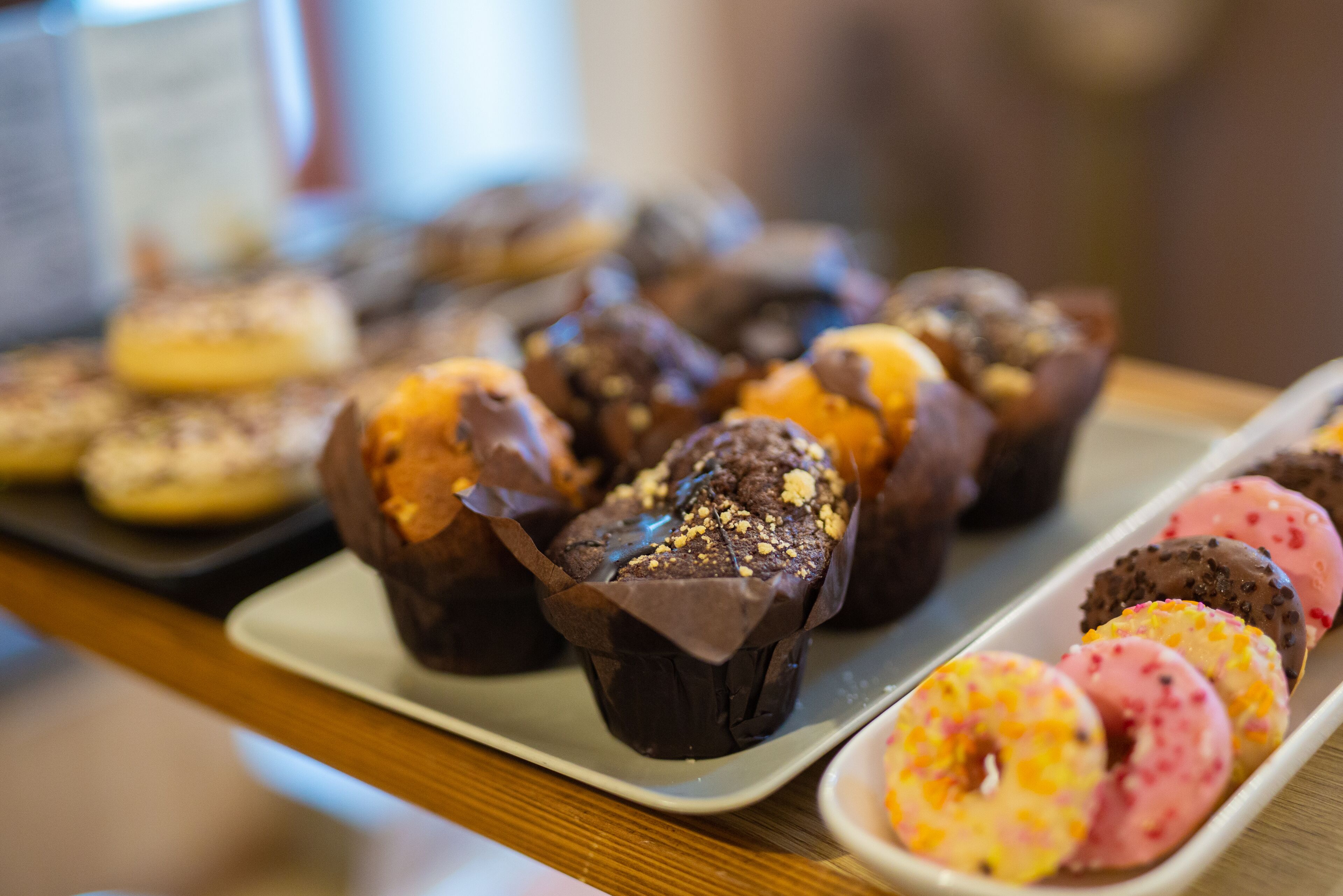 Eine Auswahl an Gebäck, darunter Schokoladenmuffins und verzierte Donuts.