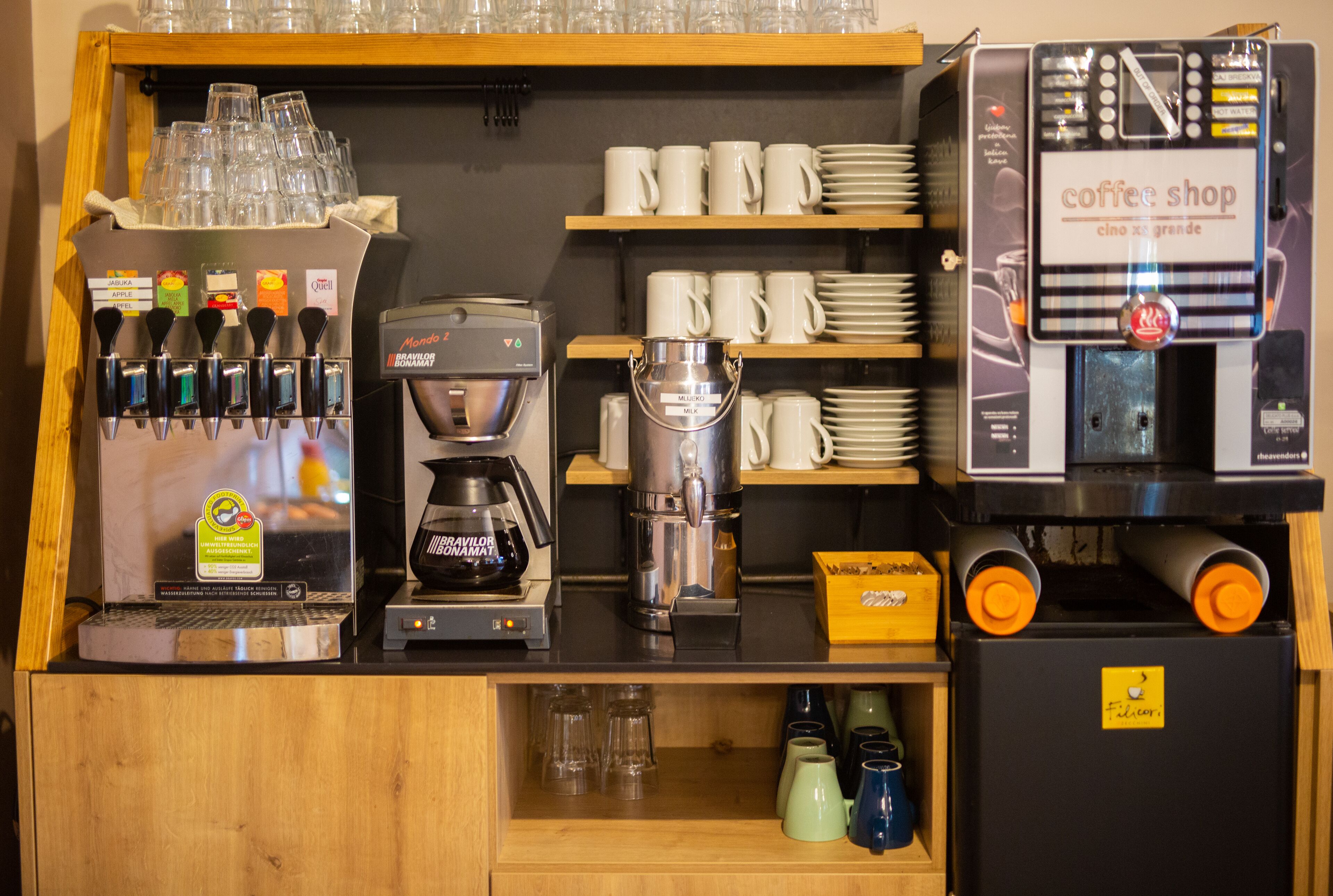 A coffee shop counter with various coffee machines, cups, and a display of coffee beans.