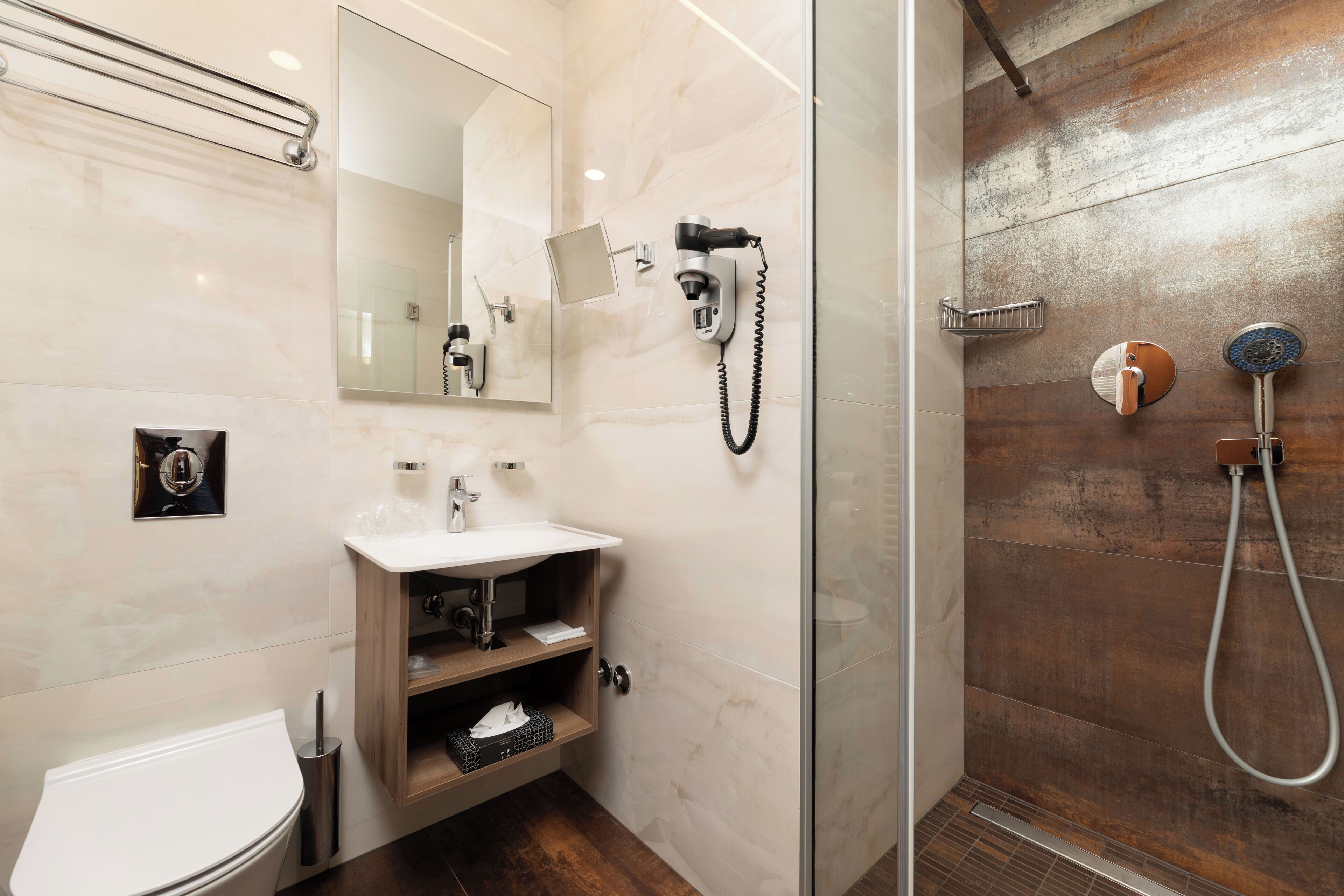 A modern bathroom with a glass-enclosed shower, a white sink, and a mirror.