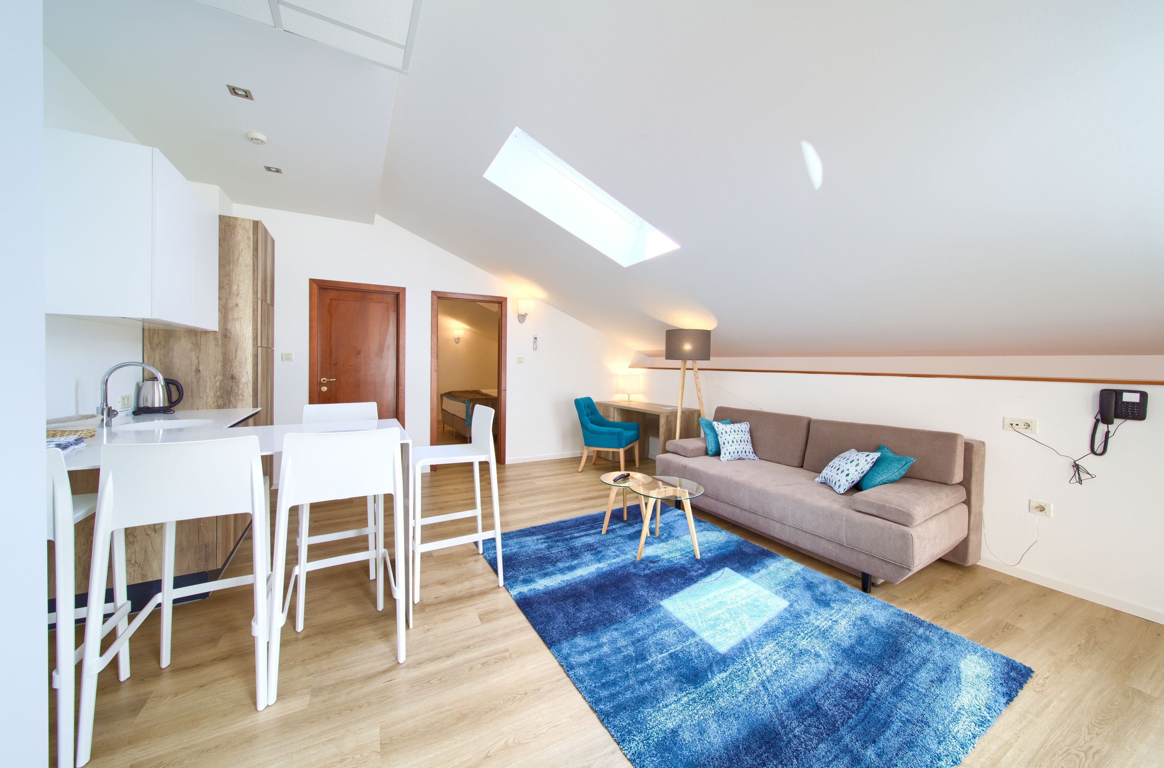 En modern lägenhet med ett matområde, en soffa och en blå matta.