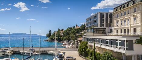 A marina with boats, a parking area, and buildings with balconies overlooking the water.