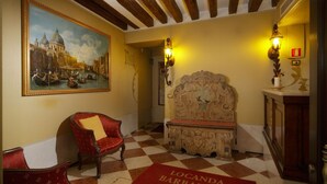 A checkered floor, a red armchair, a bench, and a painting of a canal scene.
