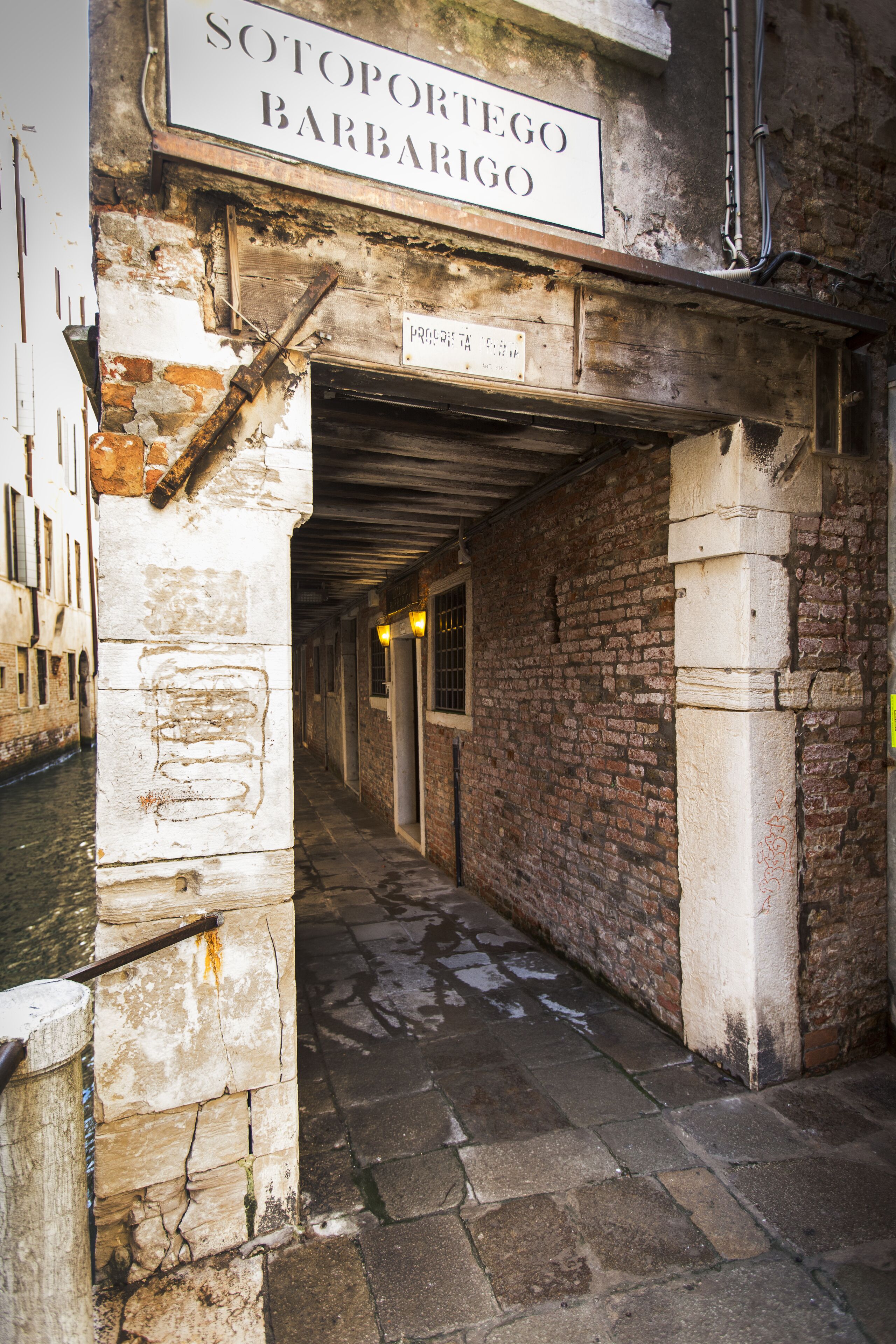Une ruelle étroite avec une enseigne indiquant : « Sotoporego Barbarigo ».