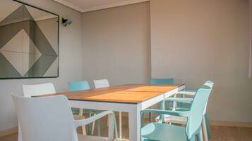 Un espace repas moderne avec une table en bois et des chaises blanches et turquoise.