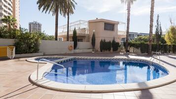 Een buitenzwembad, parasols voor strand/zwembad