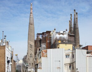A historic building with tall spires and a modern structure in the foreground. - MH Apartments S. Familia (Barcelona)