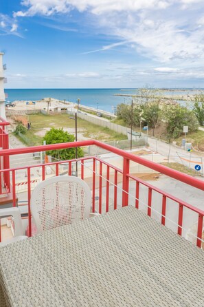 A balcony with a view of the sea, a red railing, and a white chair. - Hotel Marylise (Rimini)