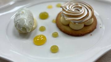 A dessert plate with a meringue-topped pastry and a scoop of ice cream.