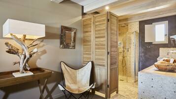 Un baño moderno con tocador de madera, zona de ducha y espejo.