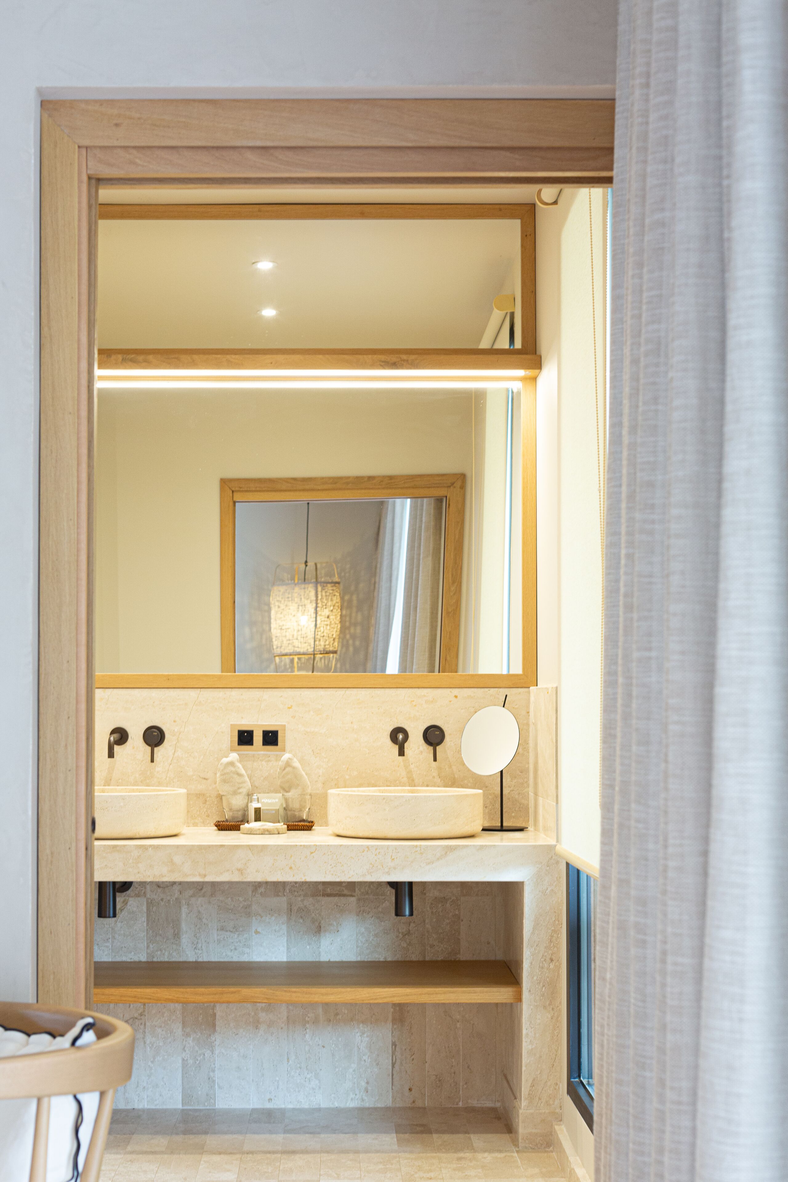 A bathroom with two sinks, a mirror, and a towel rack.