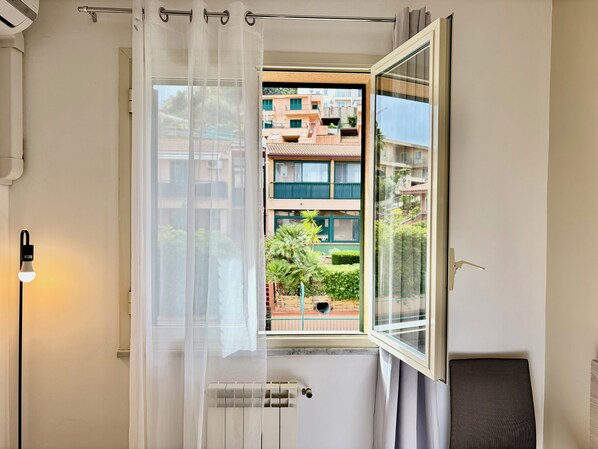 A room with a large window, a radiator, and a wall-mounted light fixture. - Ma&Mi Guest House (Cefalù)