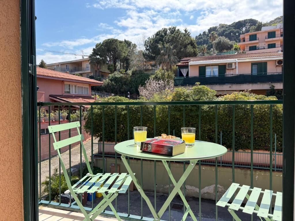 A balcony with a table, two chairs, and a book.