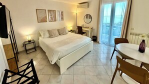 A hotel room with a bed, desk, chair, and a view of the outdoors. - Ma&Mi Guest House (Cefalù)