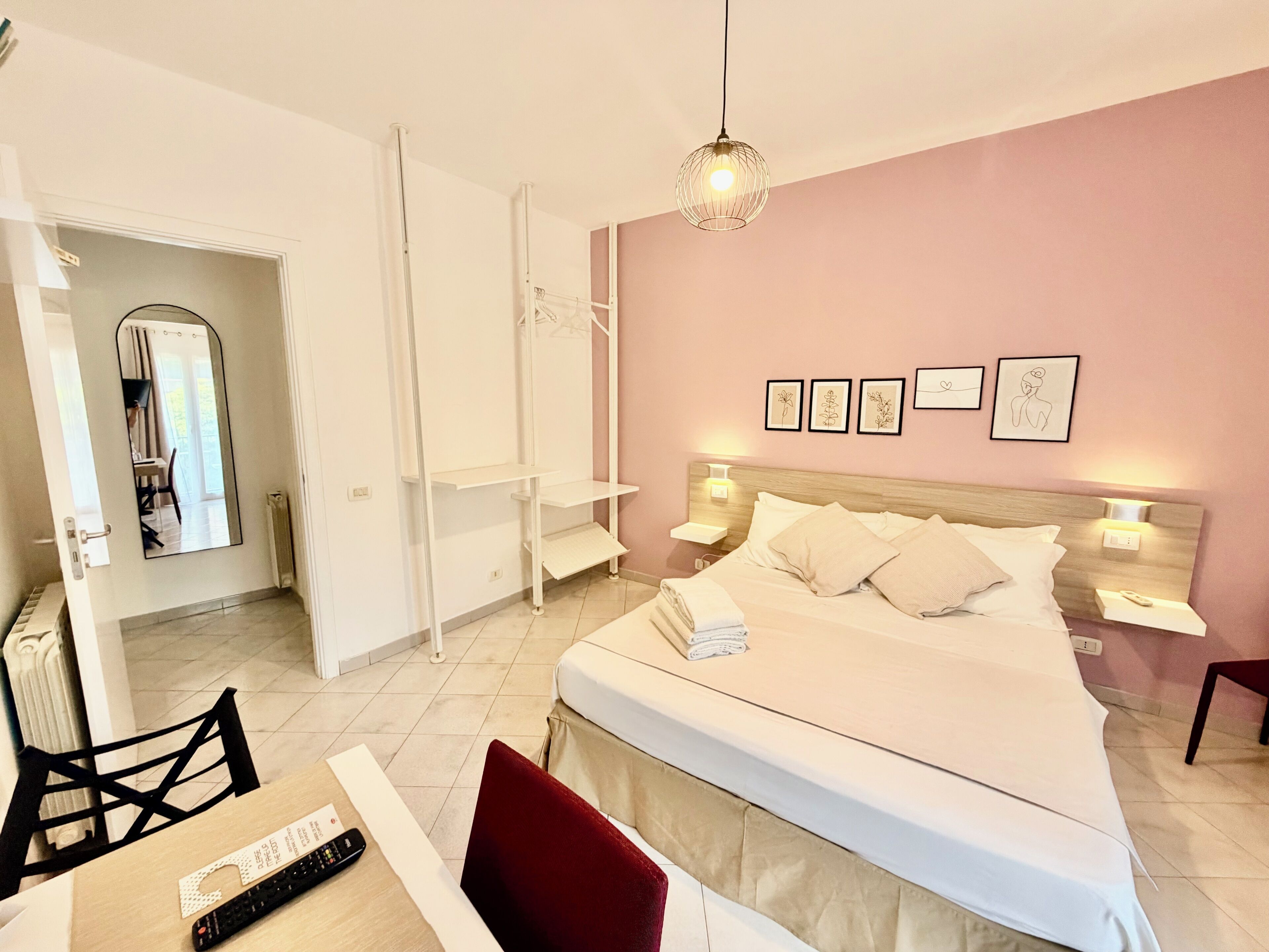 A bedroom with a bed, bedside tables, a desk, and a chair.