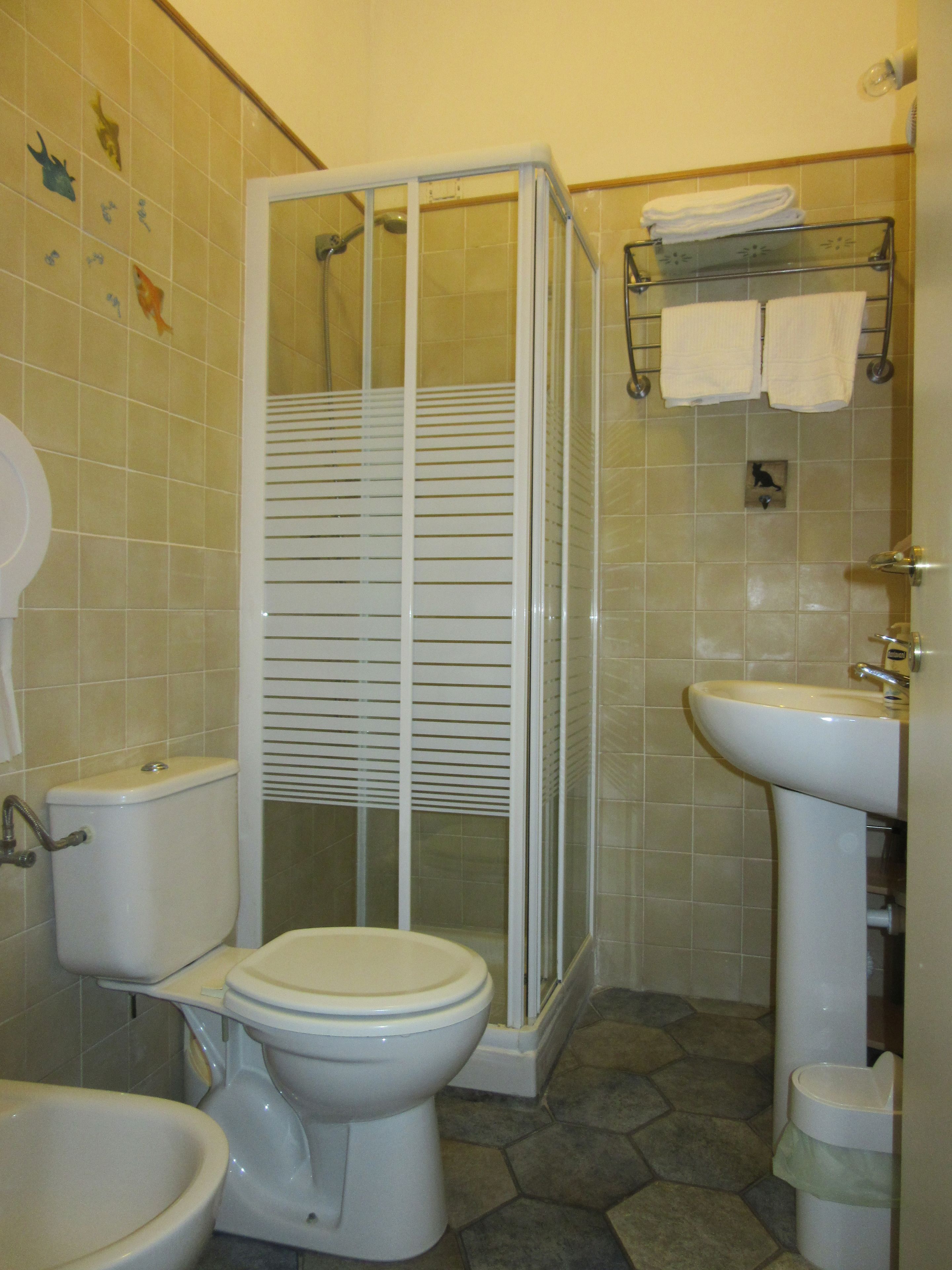 Casa de banho com sanita, bidé e cabine de duche.