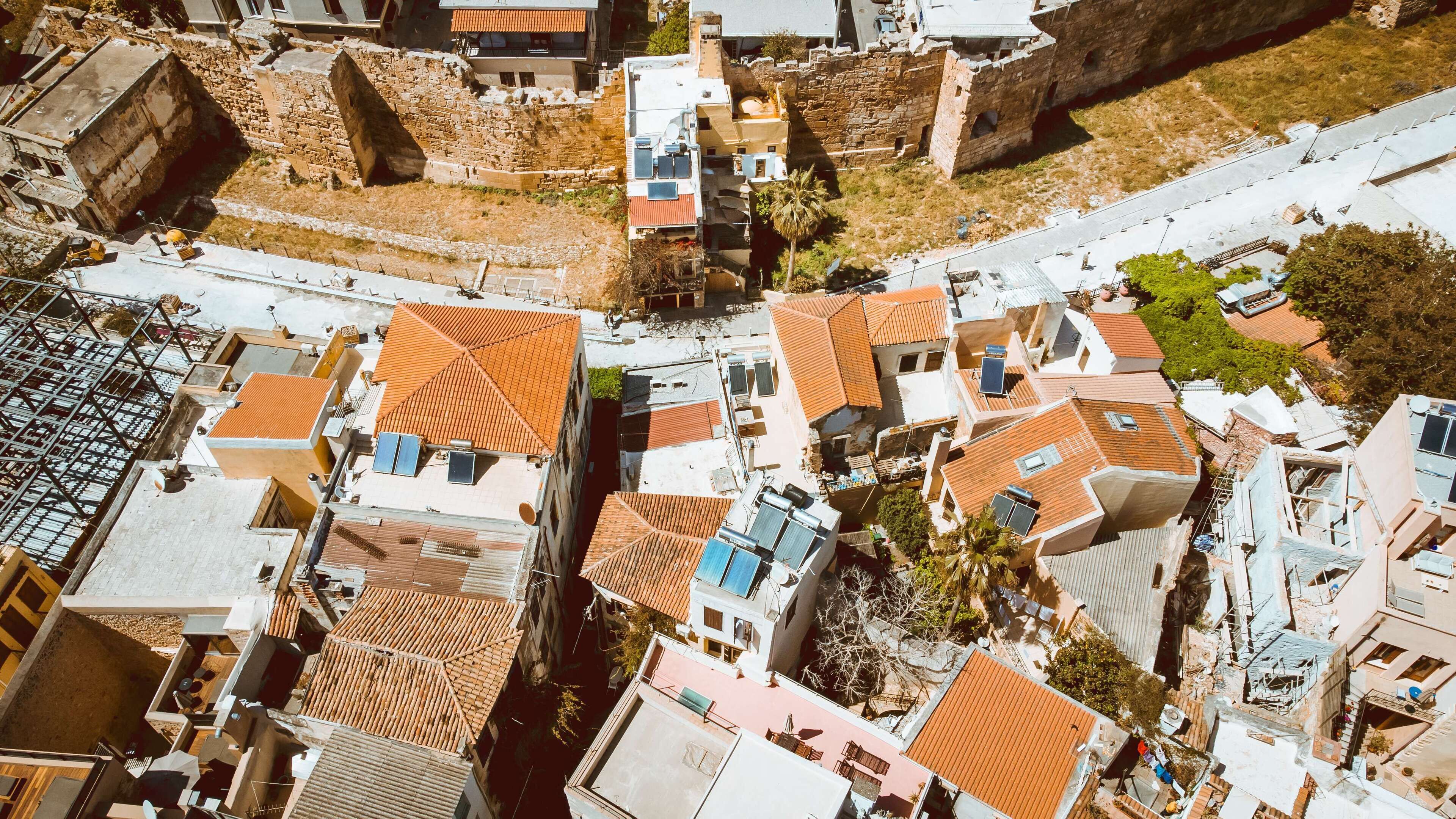 An aerial view of a densely packed urban area with closely built residential buildings, narrow streets, and a mix of modern and traditional architecture.