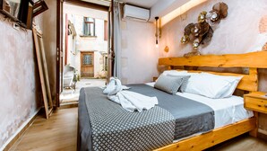 Quarto com cama de madeira, mesa de cabeceira e vista exterior.