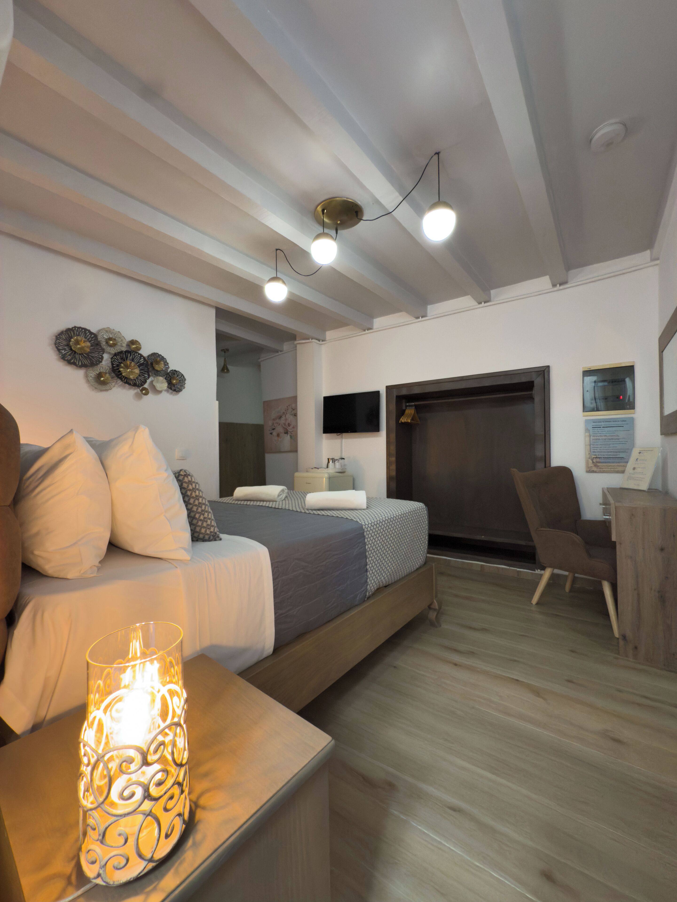 A modern bedroom with a bed, bedside table, lamp, and a chair.