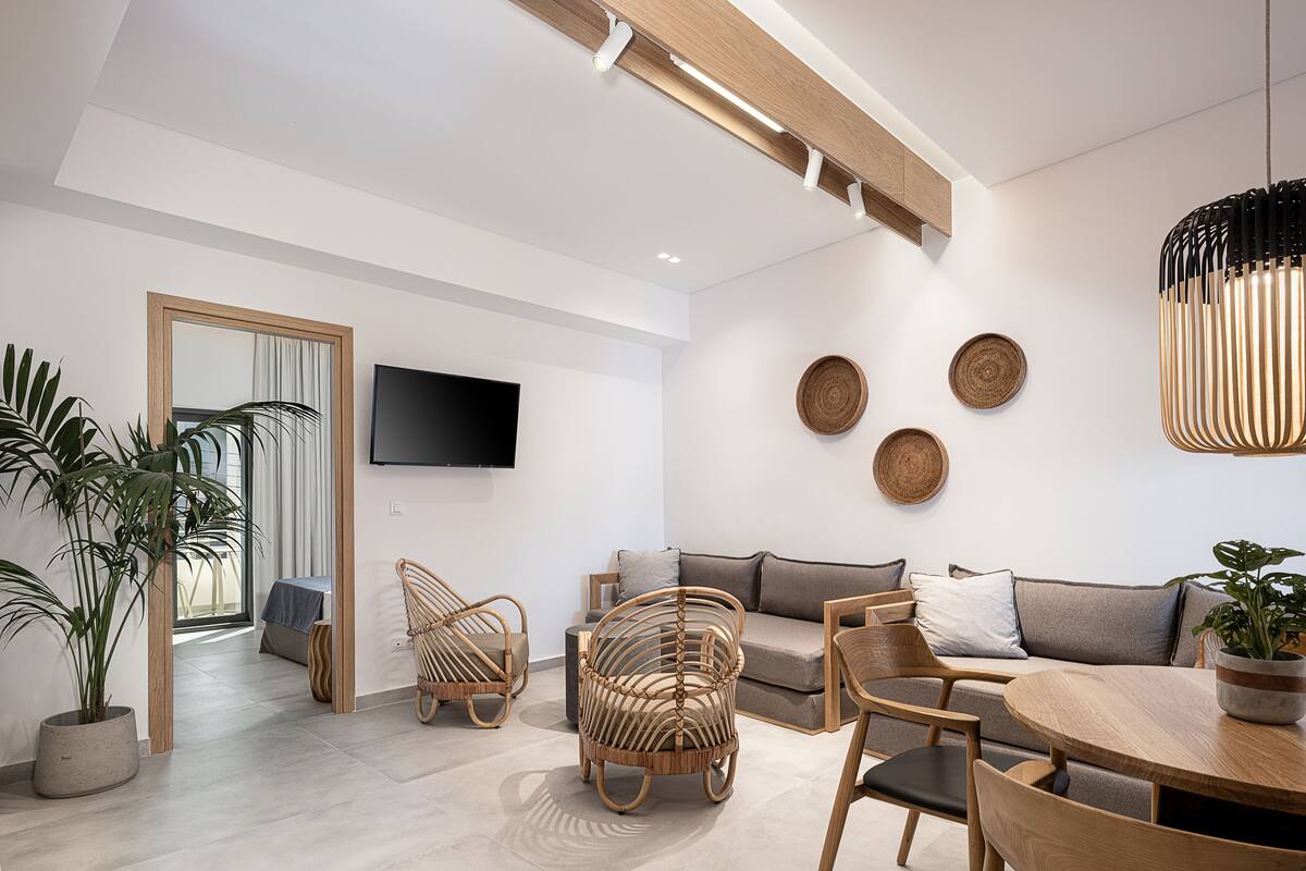 A modern living room with a sofa, chairs, a TV, and decorative items.