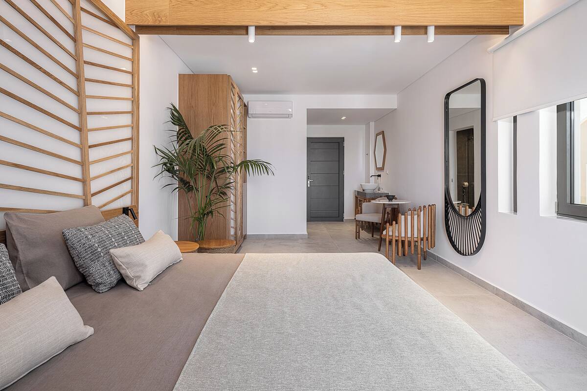 A modern living room with a sofa, a coffee table, and a large mirror.