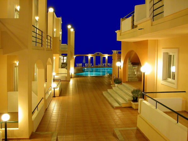 Pasillo de hotel con zona de piscina, que incluye una escalera, asientos al aire libre y vistas a la piscina.