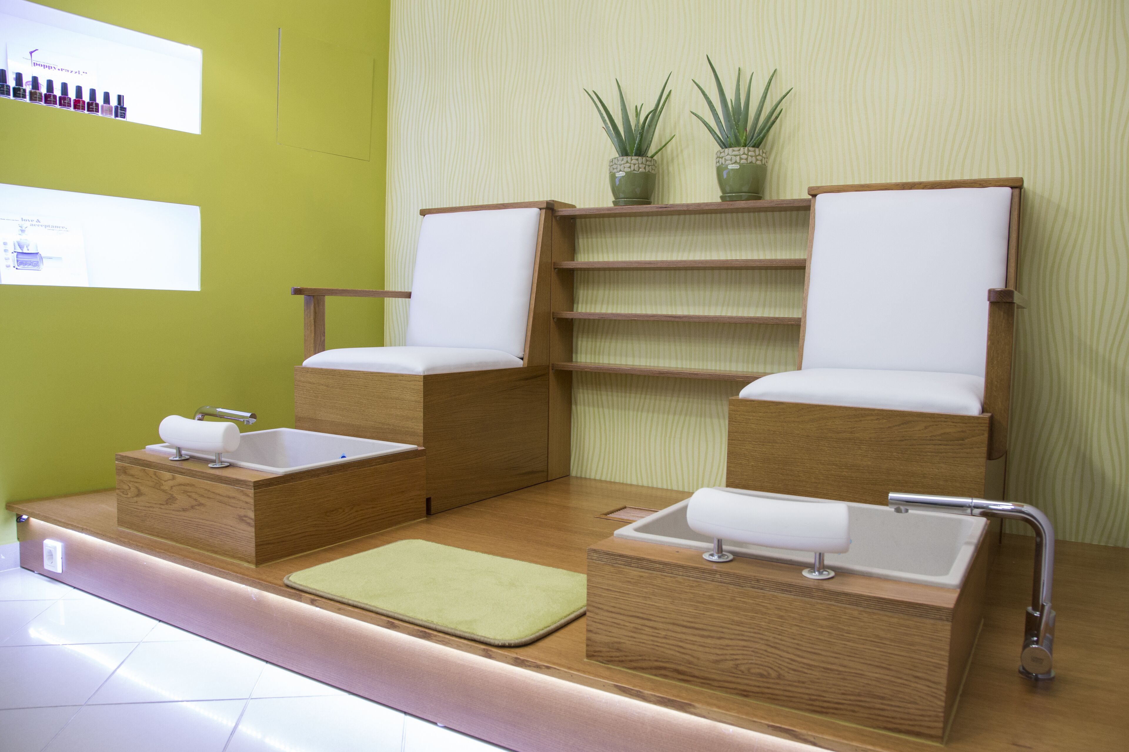 Ein modernes Badezimmer mit zwei Holzstühlen, einem Waschbecken und einem Regal mit Pflanzen.