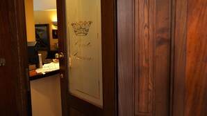 A wooden door with a glass panel displaying the words "Conte de Lavoir" and a crown symbol. - Conte Cavour (Naples)