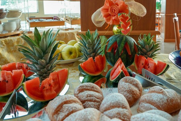 A buffet table with various fruits and pastries. - Remin Plaza (Rimini)