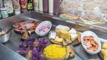 A buffet with various cheeses, meats, and condiments.