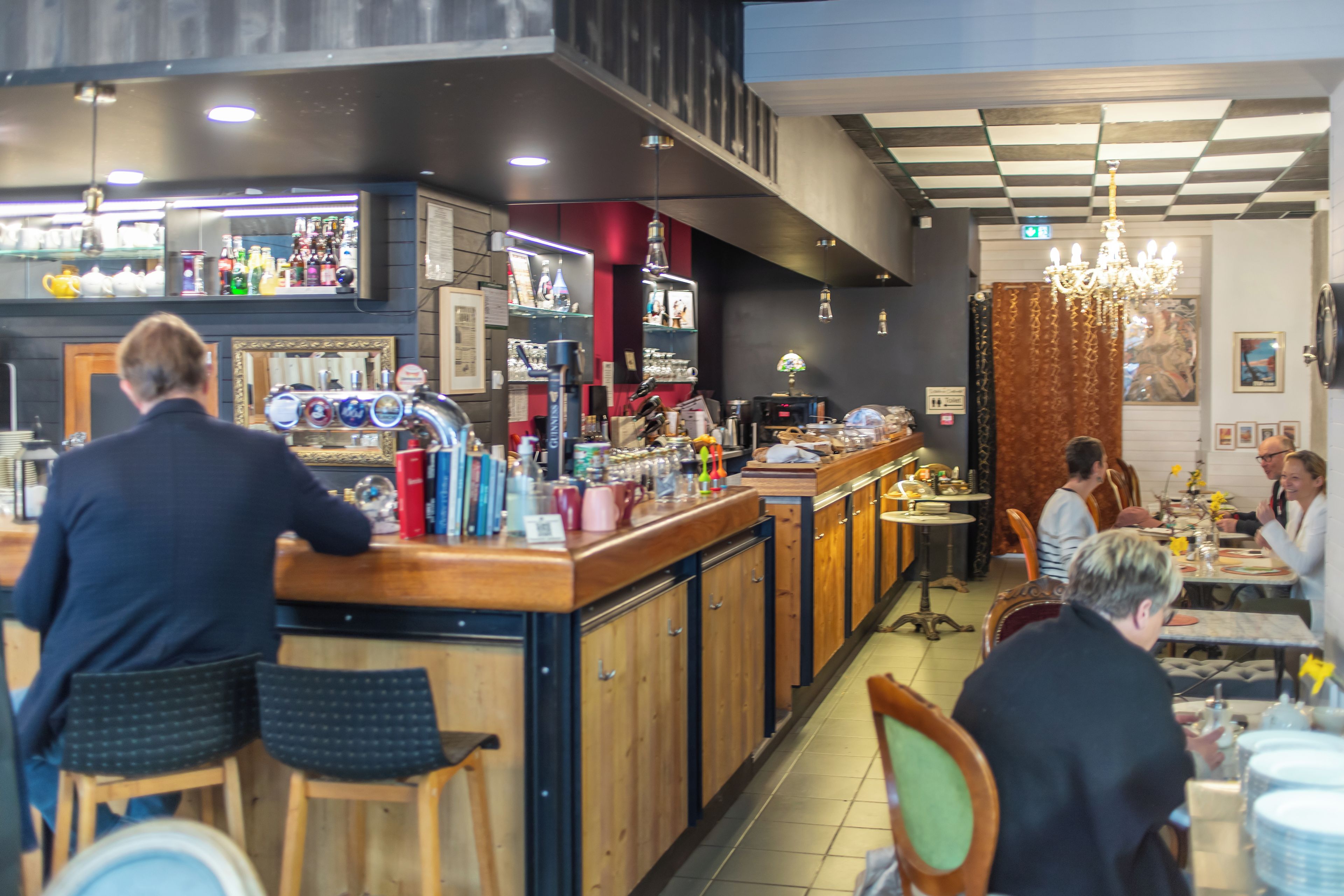 A restaurant interior with a bar area, dining tables, and chairs.