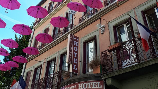 Un hôtel doté de nombreux balcons ornés de parasols roses.
