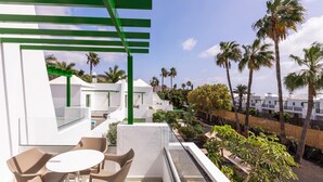 A balcony with a glass railing, a table, and chairs. - Hotel THB Royal (Yaiza)