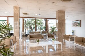 A spacious lobby with high ceilings, large windows, and a seating area with sofas and chairs. - Hotel THB Royal (Yaiza)