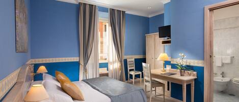 Une chambre d’hôtel avec un lit, un bureau et une salle de bain.