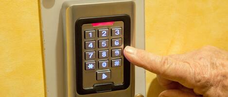 A keypad lock on a yellow door.