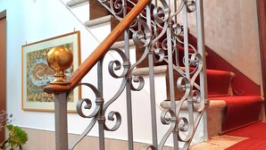 A staircase with ornate metal railings and a wooden handrail. - Residenza degli Angeli (Venice)