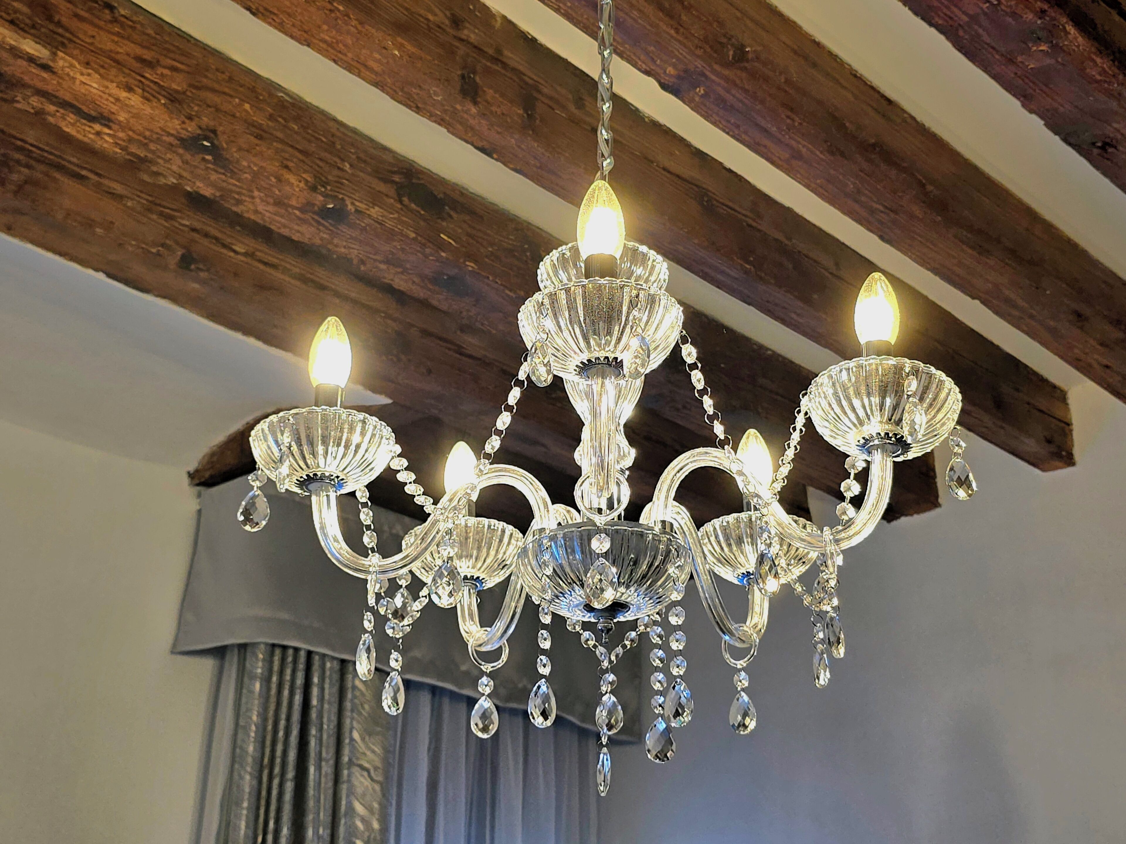 A chandelier with multiple arms and crystal decorations.